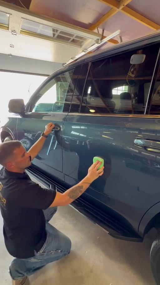 Zach Rippke applying a ceramic coating to a customer's SUV