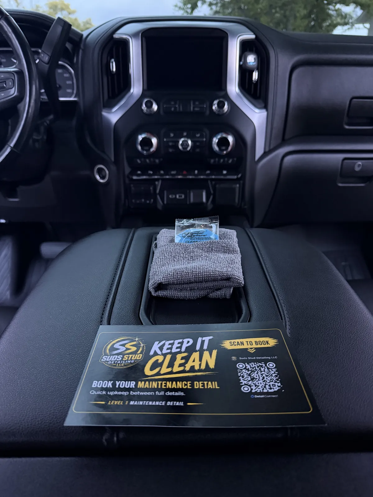 GMC Sierra interior after detailing with the Suds Stud maintenance card on the console